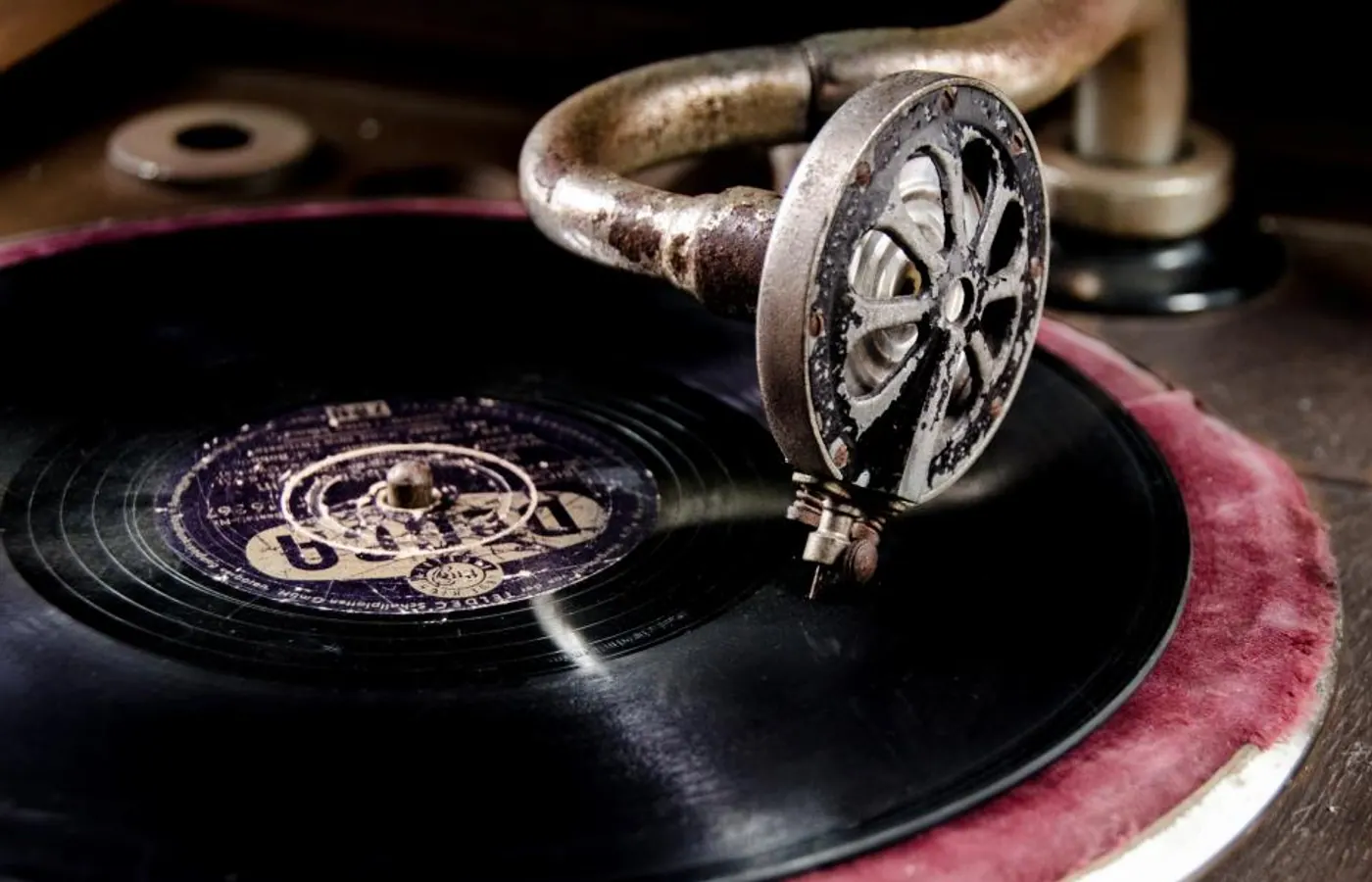 A needle resting in the groove of a record on a gramophone